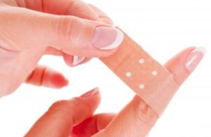 woman-putting-bandaid-on-index-finger